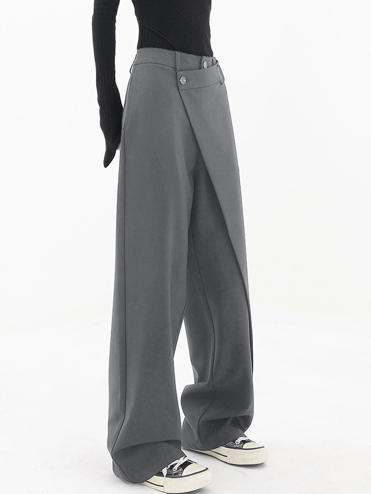 Asymmetrical layer wide-leg dress pants with button details, crafted from soft fabric for a relaxed fit and sleek silhouette.