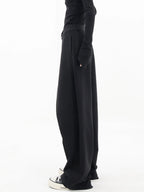 Alt text: Asymmetrical wide-leg dress pants with button details, crafted from soft fabric for comfort and a unique…