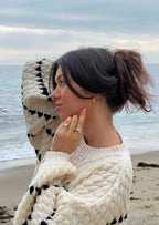 Cozy sweater featuring a textured fabric and intricate patterned design, perfect for layering during colder months.