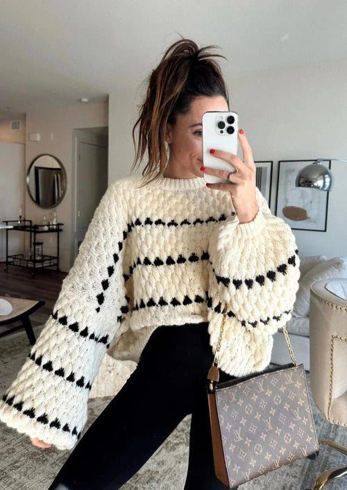 Cozy textured sweater featuring a patterned design, made from soft knit fabric for warmth and comfort in cooler weather.