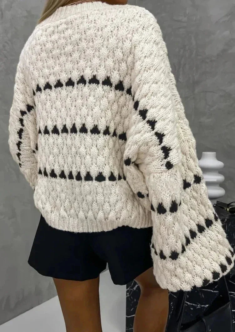 Cozy textured sweater featuring a patterned design, made from soft yarn for warmth and comfort in cool weather.