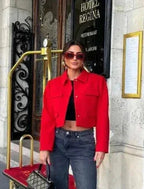 Stylish red cropped blazer with front pockets, made from lightweight fabric, perfect for layering in warm weather.