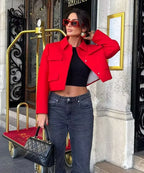 Stylish red cropped blazer made of lightweight fabric, featuring practical side pockets and a tailored fit for a modern look.