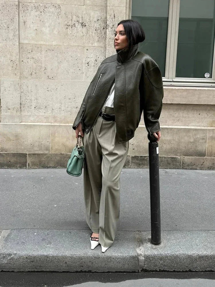 Women's army green jacket featuring a zip front and stand collar, made from durable fabric with practical pockets.