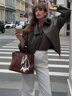 Women's army green jacket made from durable fabric, featuring a zip closure and a stand collar for added warmth.