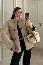 Women's beige coat featuring toggle closures, crafted from warm wool blend for comfort and style during chilly weather.
