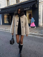 Women's beige coat with toggle closures, featuring a soft fabric and a classic design for versatile layering.