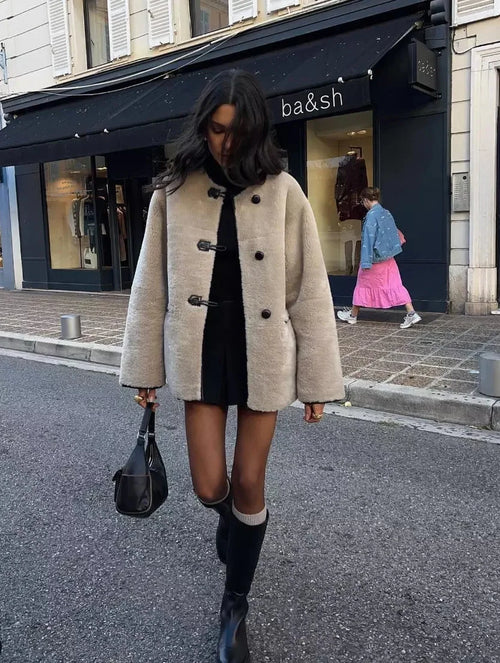 Women's beige coat with toggle closures, featuring a soft fabric and a classic design for versatile layering.