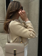 Women's beige cropped cardigan featuring a button front, made from soft cotton blend for comfortable layering.