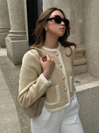 Women's beige cropped cardigan with button front, made from soft cotton blend, featuring a comfortable fit and ribbed…