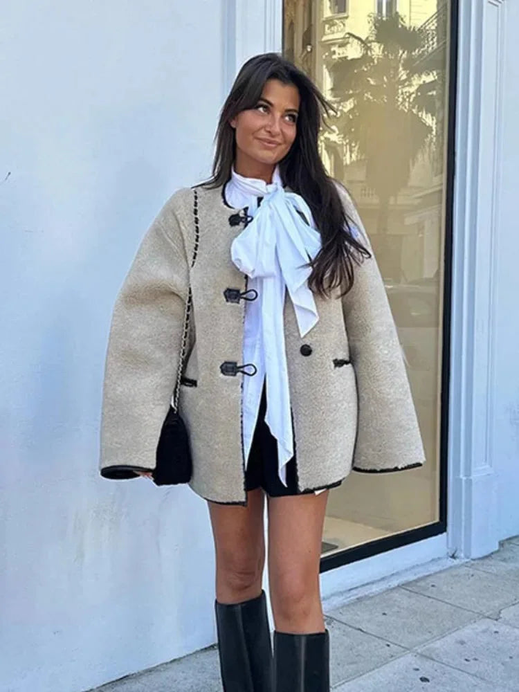 Women's beige fleece jacket featuring double-breasted buttons and a soft, cozy texture for warmth and style.