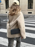 Women's beige fleece jacket featuring double-breasted buttons and a cozy, soft texture perfect for cooler weather.