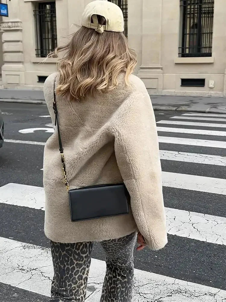 Women's beige fleece jacket featuring double-breasted buttons and a cozy, soft texture perfect for cooler weather.
