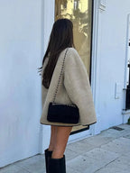 Women's beige fleece jacket featuring double-breasted buttons and a soft, warm fabric ideal for chilly days.