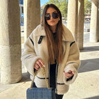 Women's oversized beige teddy coat with black accents, featuring a soft fleece material and a cozy, relaxed fit.