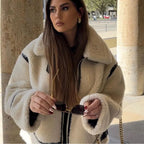 Women's beige oversized teddy coat featuring black accents, soft texture, and a cozy, relaxed fit for casual layering.