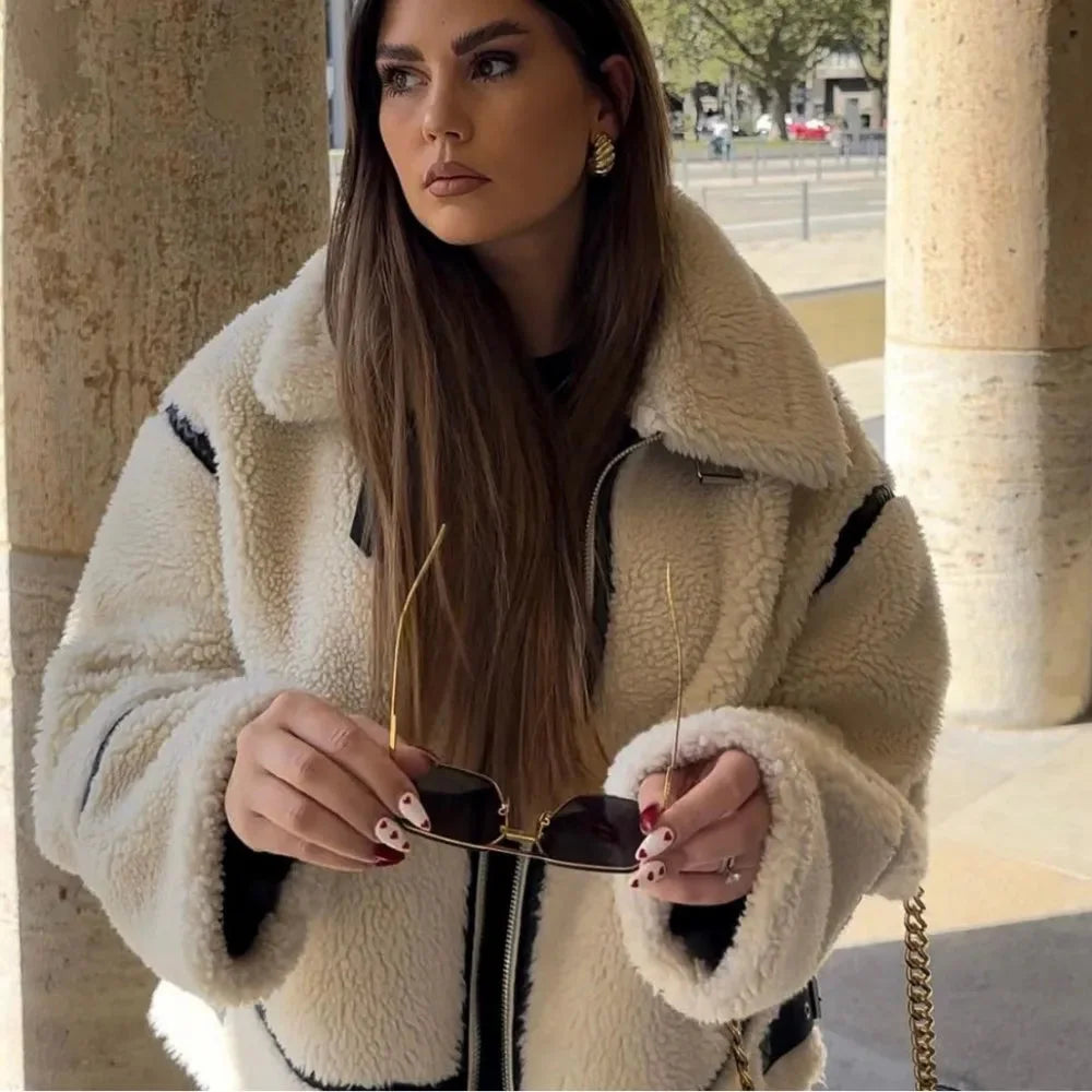 Women's beige oversized teddy coat featuring black accents, soft texture, and a cozy, relaxed fit for casual layering.