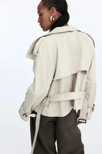 Women's beige short trench coat made of breathable cotton, featuring a belted waist and classic double-breasted design.