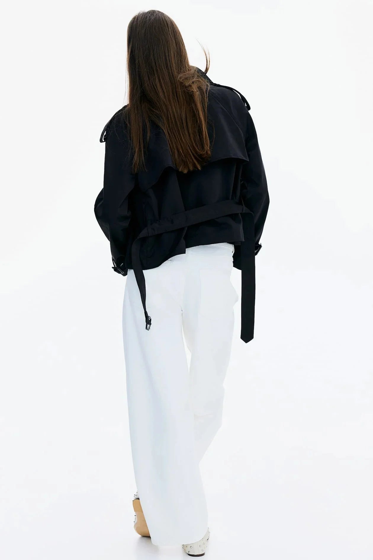 Women's beige short trench coat featuring a belted waist, made from lightweight fabric with classic double-breasted design.