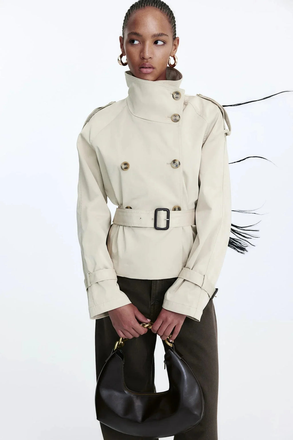 Women's beige short trench coat with belt, featuring lightweight fabric, classic design, and shoulder epaulettes for added…