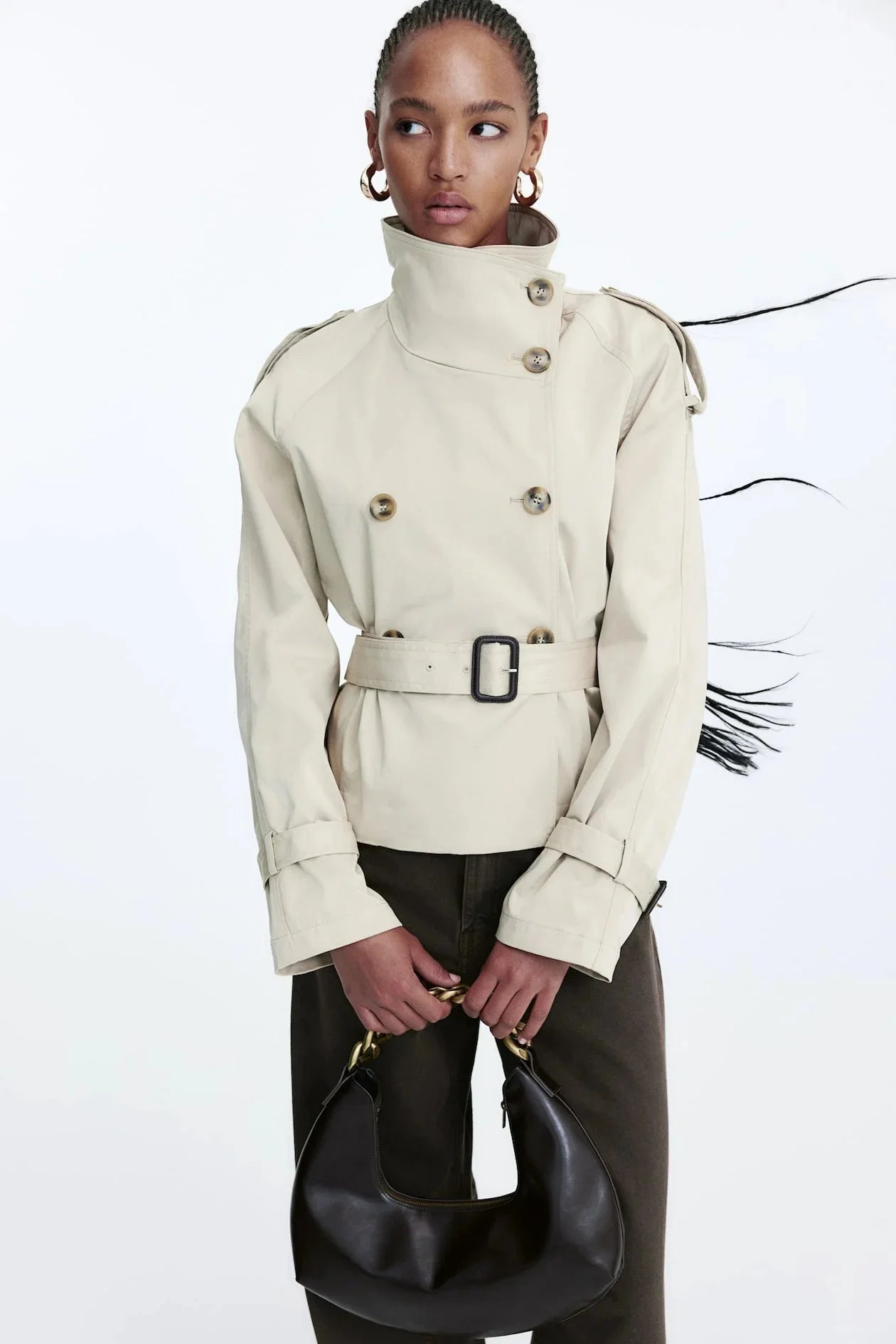 Women's beige short trench coat with belt, featuring lightweight fabric, classic design, and shoulder epaulettes for added…