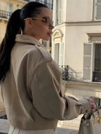 Women's beige suede cropped jacket featuring a stylish lapel collar and a soft texture, perfect for layering in cool weather.
