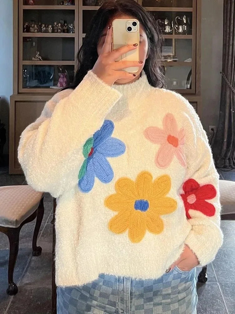 Women's beige sweater featuring a colorful floral design, crafted from soft knit fabric for comfortable, everyday wear.