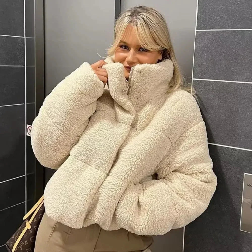 Women's beige teddy bomber coat featuring a high collar, crafted from soft, plush material for warmth and comfort.