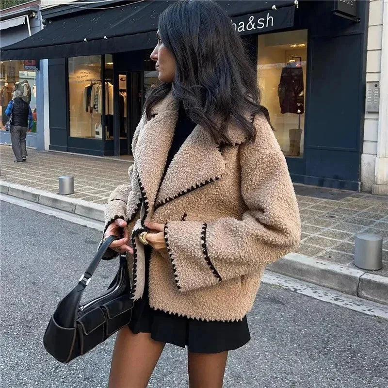 Alt text: Women's beige teddy jacket featuring soft fabric and intricate stitching, perfect for layering in cool weather.