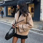 Alt text: Women's beige teddy jacket featuring soft fabric and intricate stitching, perfect for layering in cool weather.