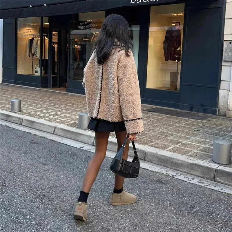Women's beige teddy jacket featuring detailed stitching and a soft, cozy texture, perfect for cool weather layering.