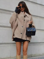Women's beige vintage-inspired oversized coat made from soft wool blend with large buttons and a belted waist for a relaxed…