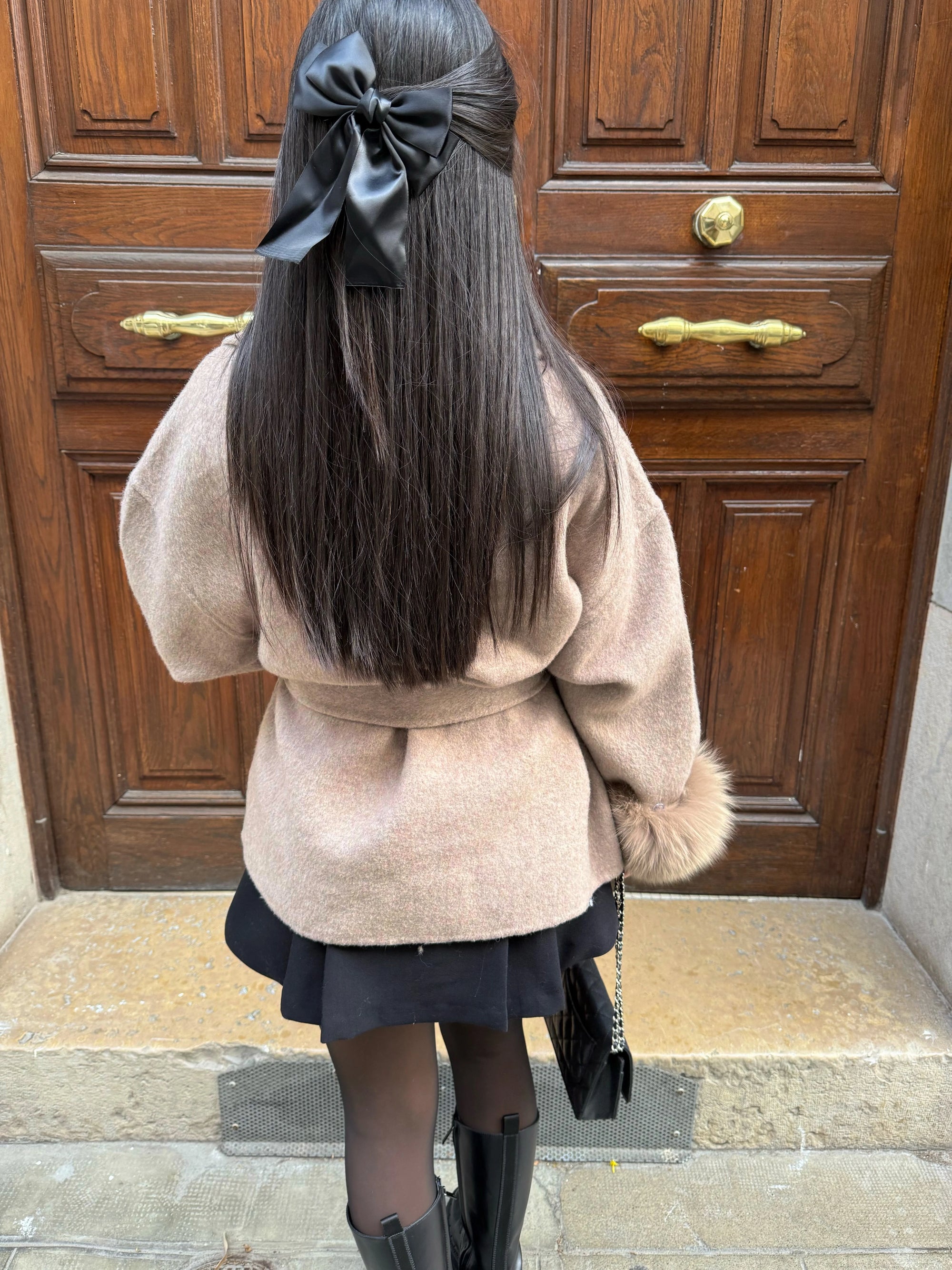 Women's belted coat featuring soft plush cuffs, a tailored silhouette, and a classic design, ideal for chilly weather.