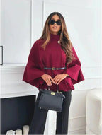 Women's belted poncho featuring button details, flared sleeves, and a soft knit fabric for comfort and style.