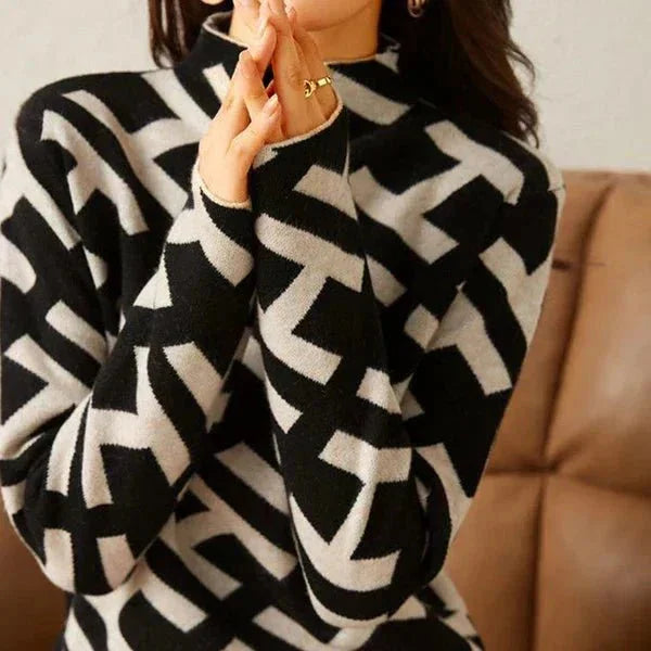 Women's black and white geometric pattern sweater made of soft knit fabric with a relaxed fit and round neckline.