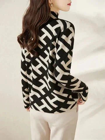 Women's black and white geometric pattern sweater made from soft knit fabric, featuring a cozy, relaxed fit and long sleeves.