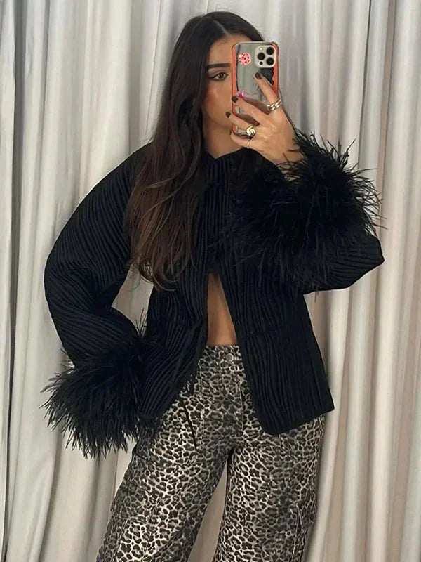 Women's black jacket with feather cuffs, featuring a stylish design and soft fabric for a sophisticated look.