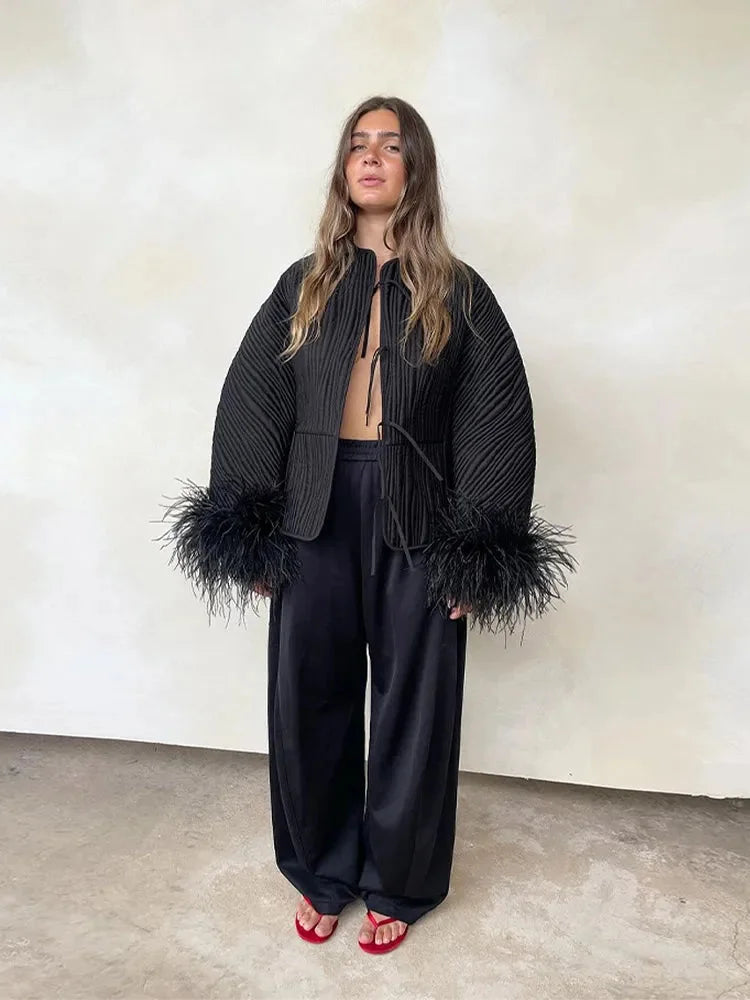 Women's black jacket featuring feather cuffs, crafted from soft fabric with a tailored fit and elegant design.