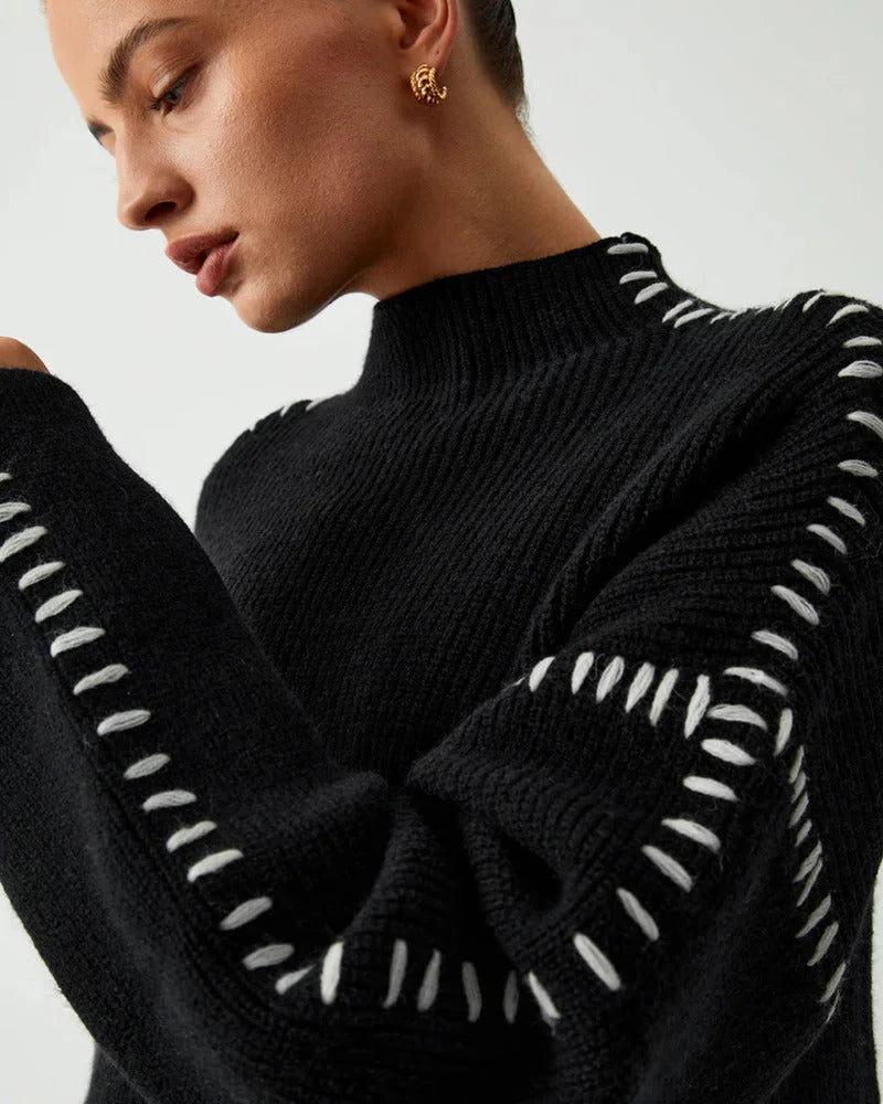 Women's black sweater featuring white stitch detail, crafted from soft cotton blend for comfort and style in everyday wear.