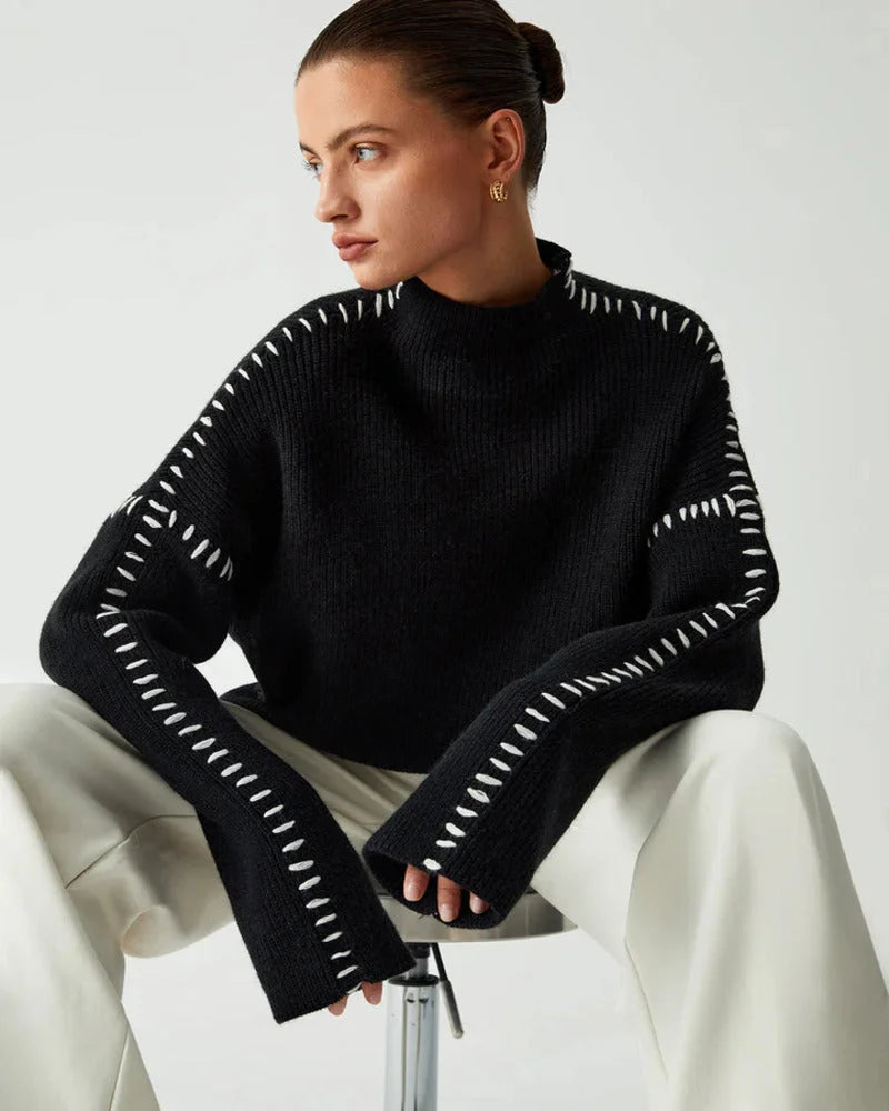 Women's black sweater featuring white stitch detail, crafted from soft cotton blend for comfort and style.