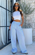 Women's blue striped wide-leg pants featuring an elastic waistband, made of lightweight fabric for comfort and ease of…