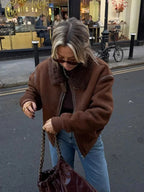 Women's brown aviator jacket made of faux leather with a cozy faux shearling collar and zippered front closure.
