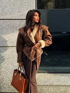 Women's brown belted coat featuring a shearling collar, crafted from warm fabric for added comfort and style in cold weather.