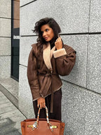 Women's brown coat with a belted waist and shearling collar, made from warm fabric for comfort in chilly weather.