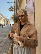 Women’s brown cropped suede jacket featuring zip closure and functional pockets for a stylish and practical look.