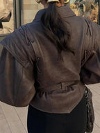 Women's brown tie-waist jacket featuring a structured design, crafted from soft fabric for a tailored fit and modern…