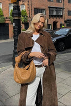 Women's brown trench coat featuring a belted waist, lapel collar, and durable fabric, perfect for stylish layering.