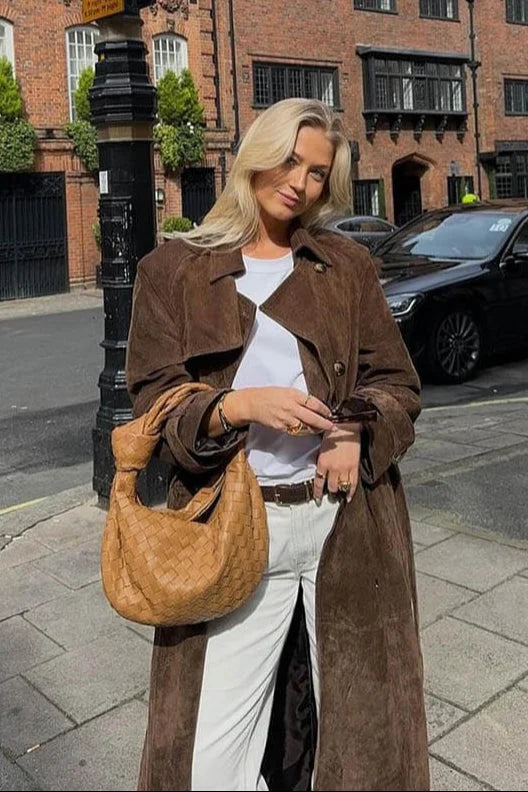 Women's brown trench coat featuring a belted waist, lapel collar, and durable fabric, perfect for stylish layering.