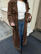 Women's brown trench coat made of soft fabric, featuring a waist belt and classic lapels for a tailored look.