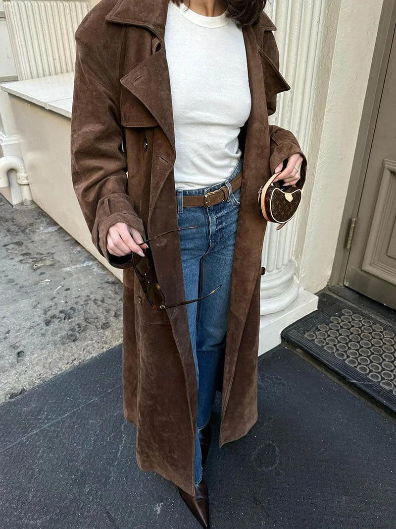 Women's brown trench coat made of soft fabric, featuring a waist belt and classic lapels for a tailored look.